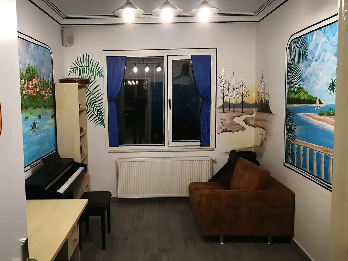 Duvar resimleriyle bezenmiş, piyanolu ders odası